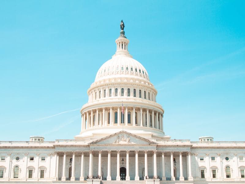 The United States Capitol dome in Washington, DC under a clear blue sky