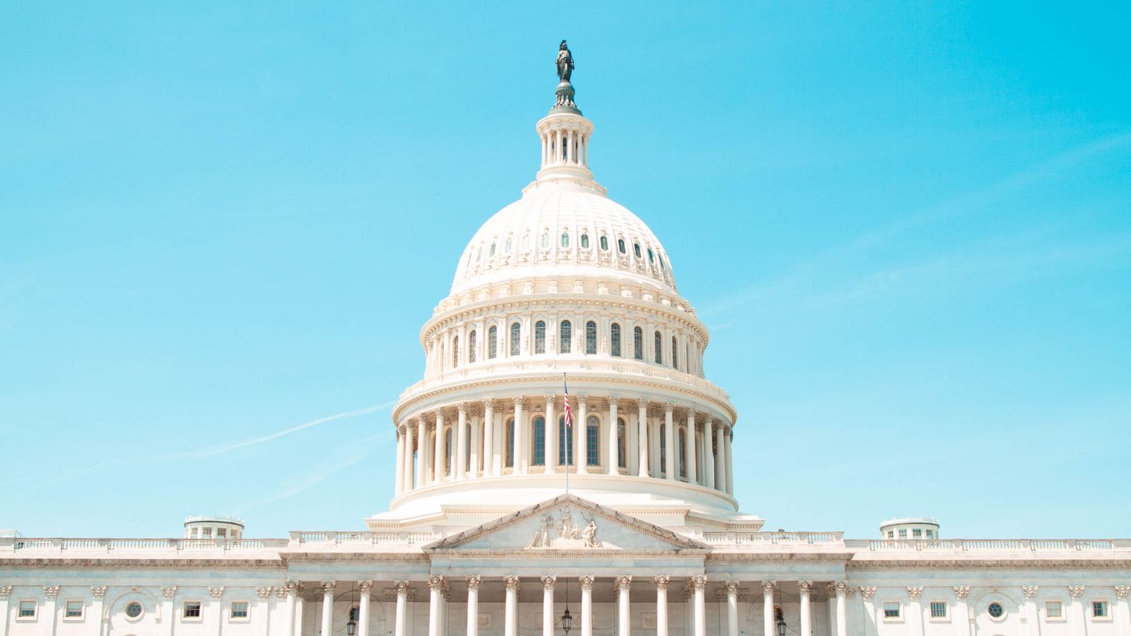 The United States Capitol dome in Washington, DC under a clear blue sky