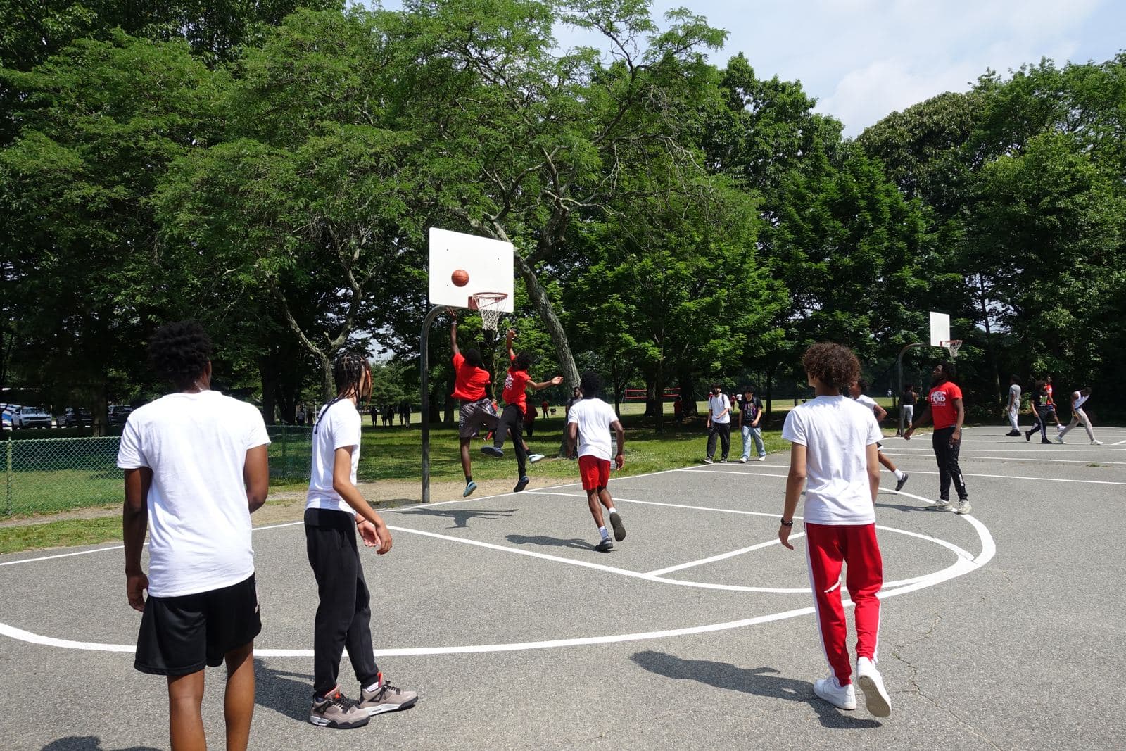Students playing pickup basketball at a state park court