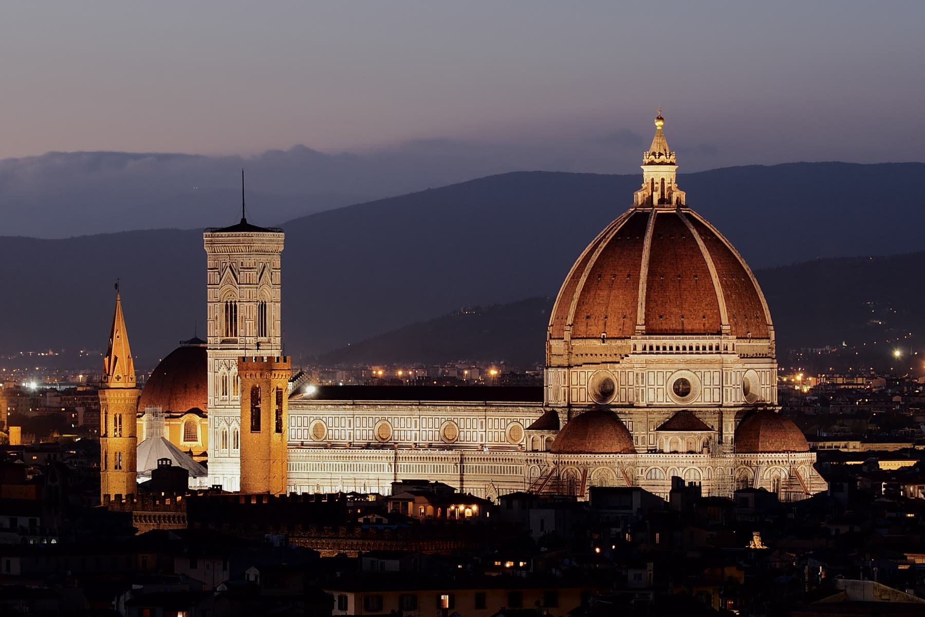 The Florence Cathedral and Brunelleschi's dome lit at dusk above the city