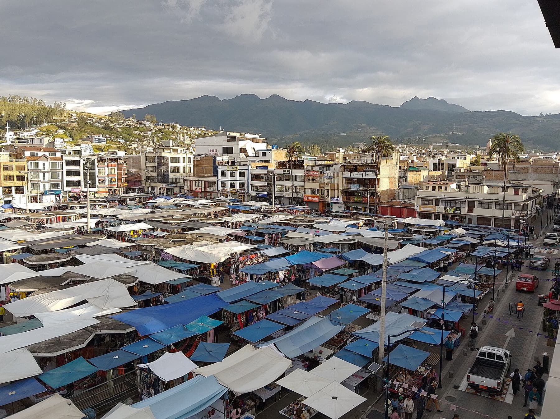 The textile market in Otavalo, Ecuador, with the Andes behind it