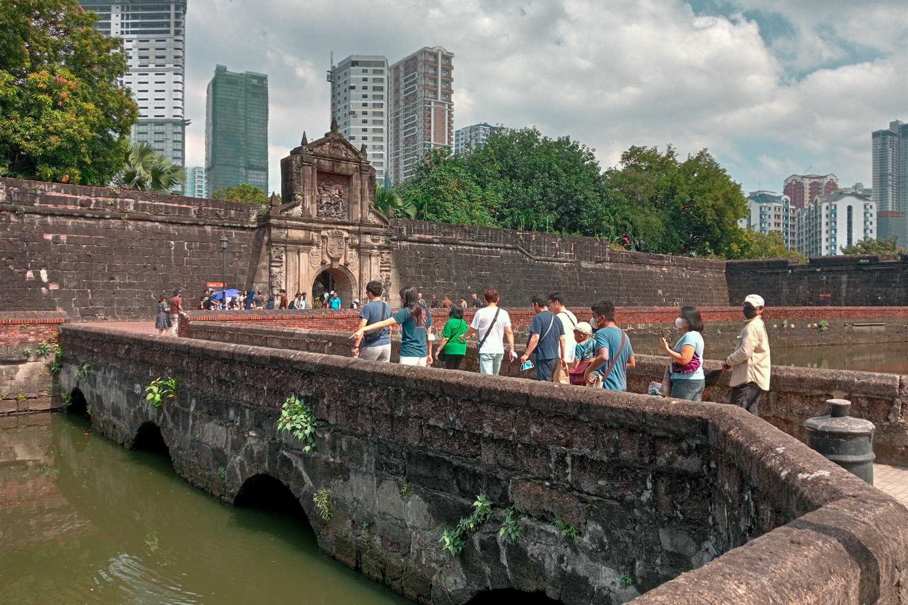 Visitors crossing the stone bridge to the gate of Fort Santiago in Intramuros, Manila