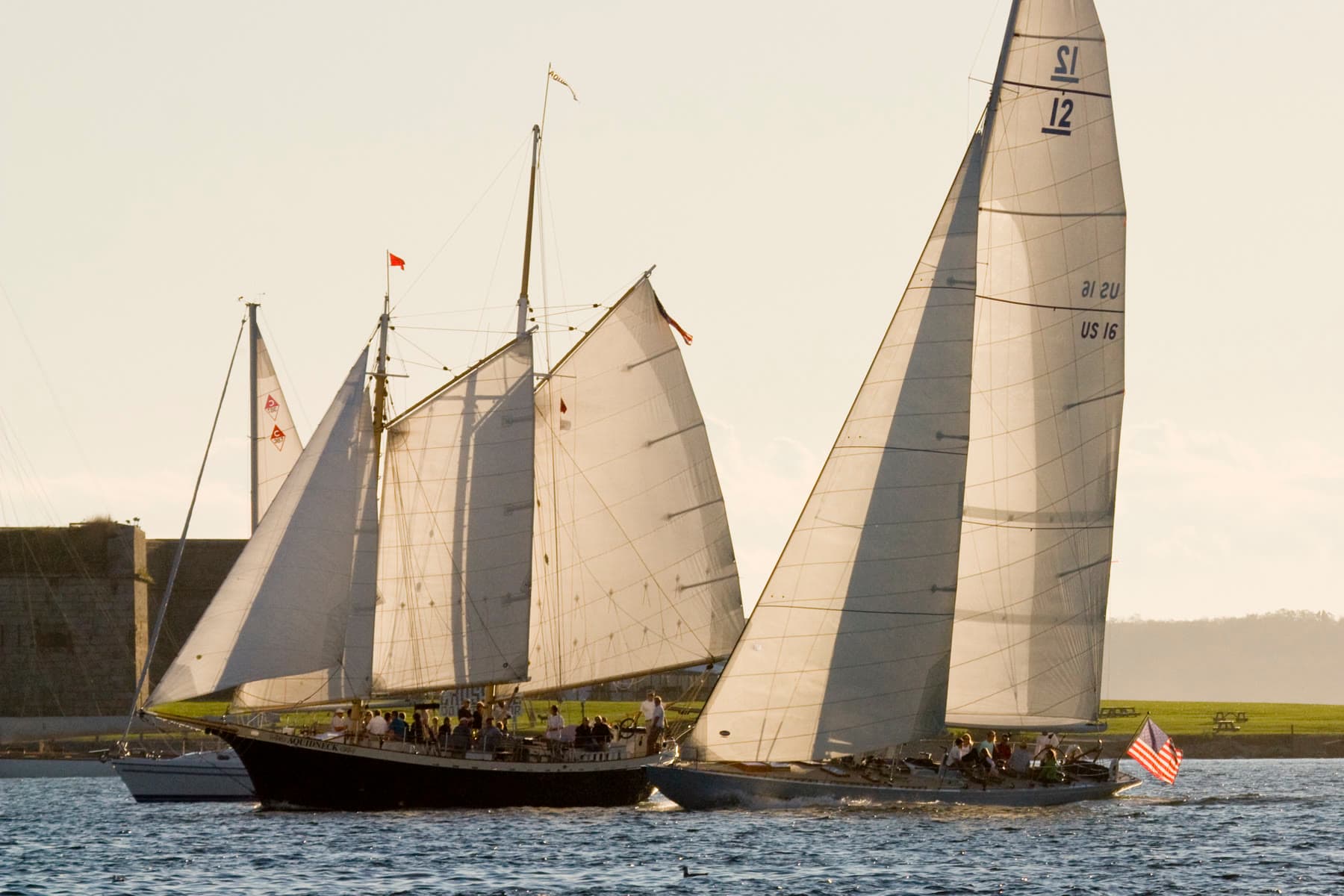 Classic sailing yachts on the water beside Fort Adams in Newport