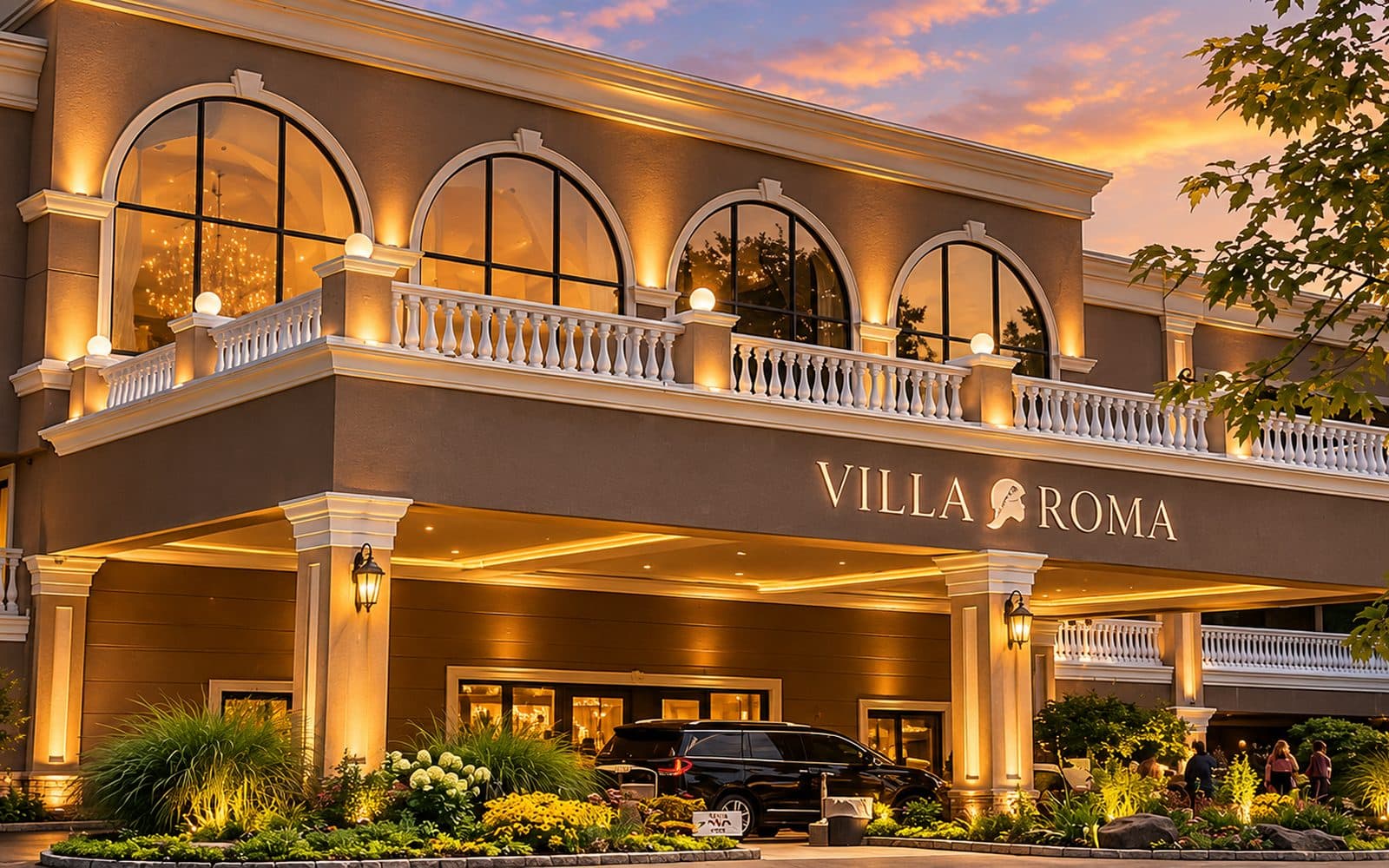 The illuminated entrance of Villa Roma Resort at dusk