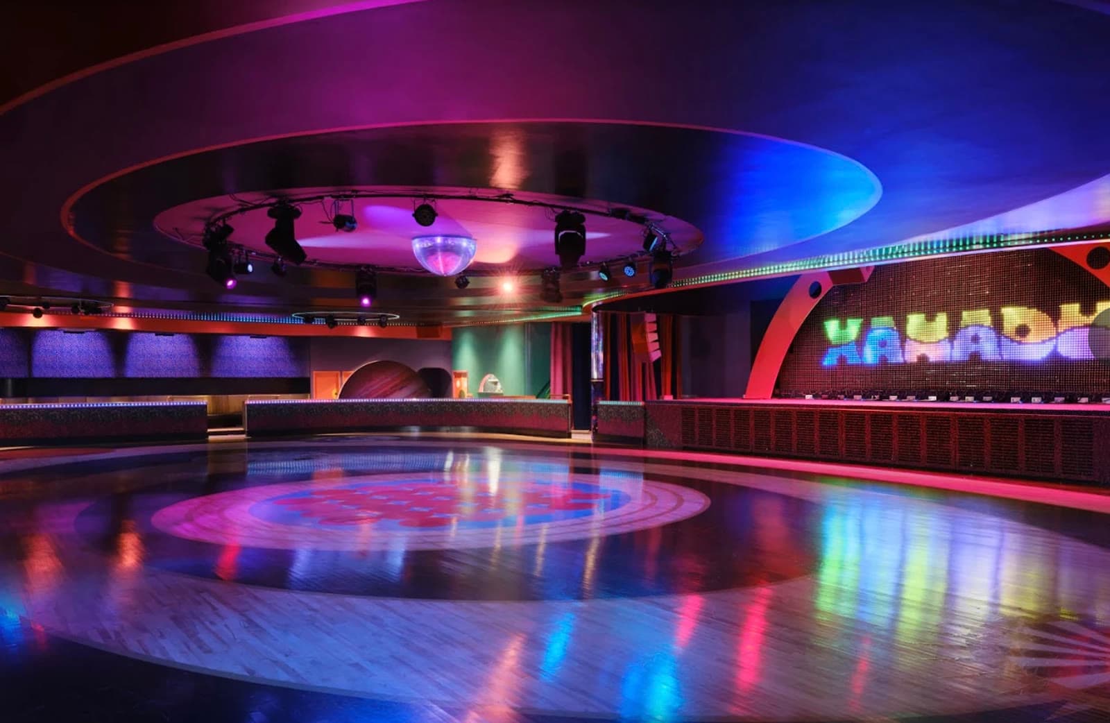 An indoor roller skating rink with a polished wood floor